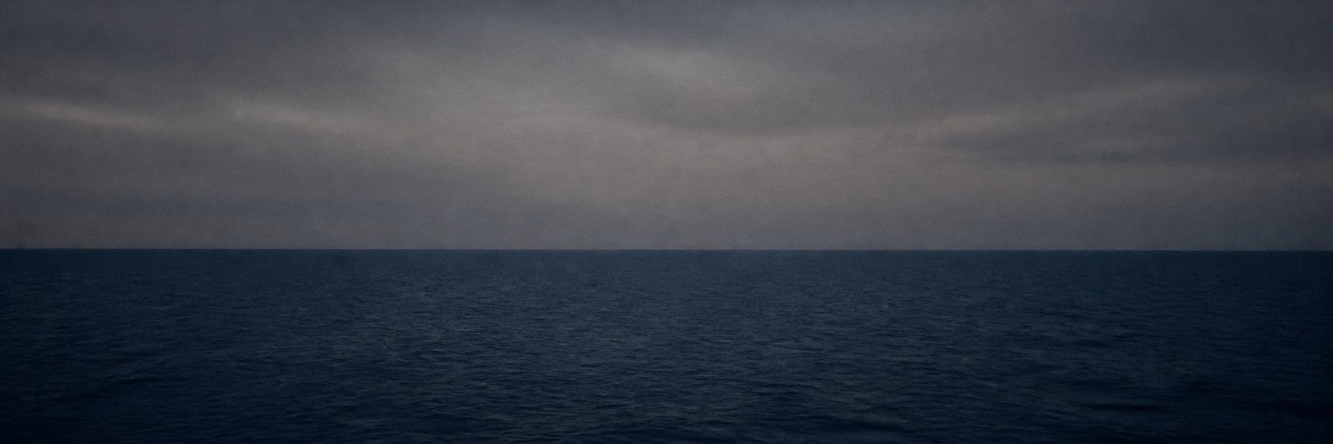 Open sea meeting a dim sky at dusk