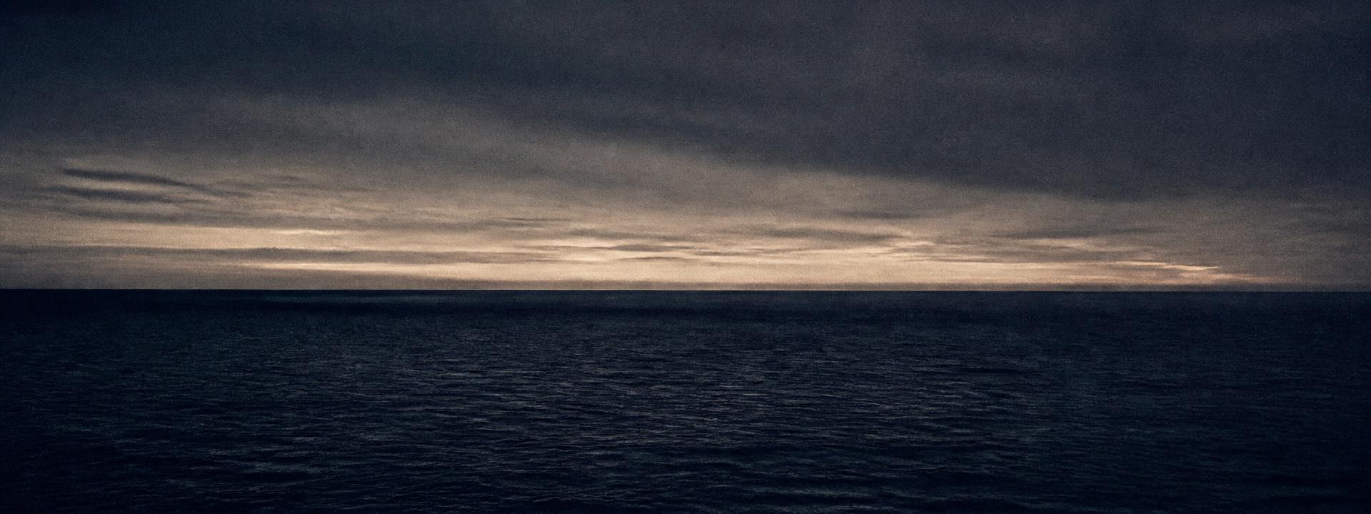 A calm open-water horizon at dusk