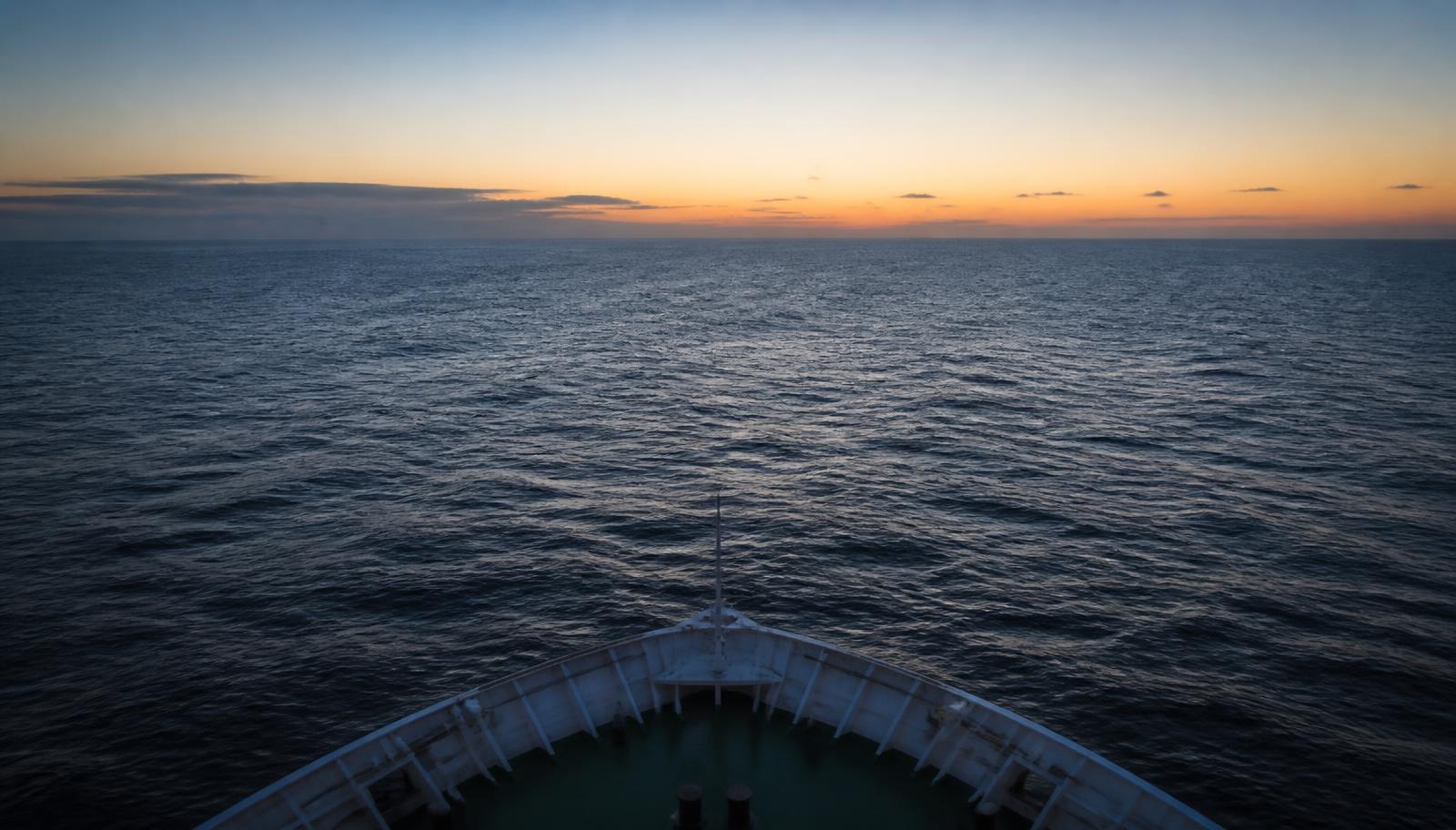 Open ocean at dawn seen from the bow of a transport vessel
